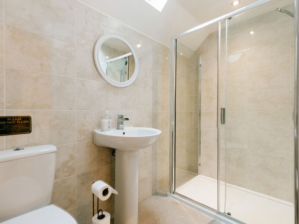A bathroom with a toilet, sink, and shower at Sage Lodge in Brigg