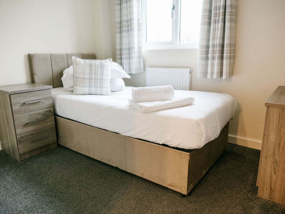 A bedroom with a single bed and a nightstand at Sage Lodge in Brigg