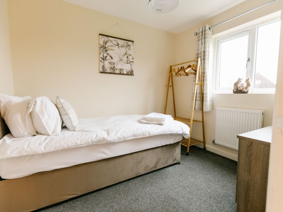 A bedroom with a bed and a clothing rack at Sage Lodge in Brigg