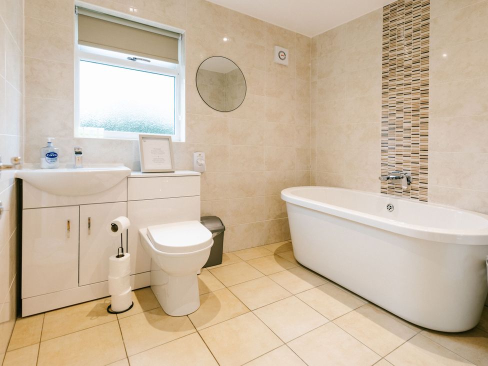 A bathroom with a bathtub, toilet, and sink at Sage Lodge in Brigg