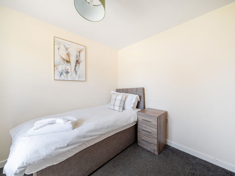 A bedroom with a single bed and bedside table at Sage Lodge near Brigg
