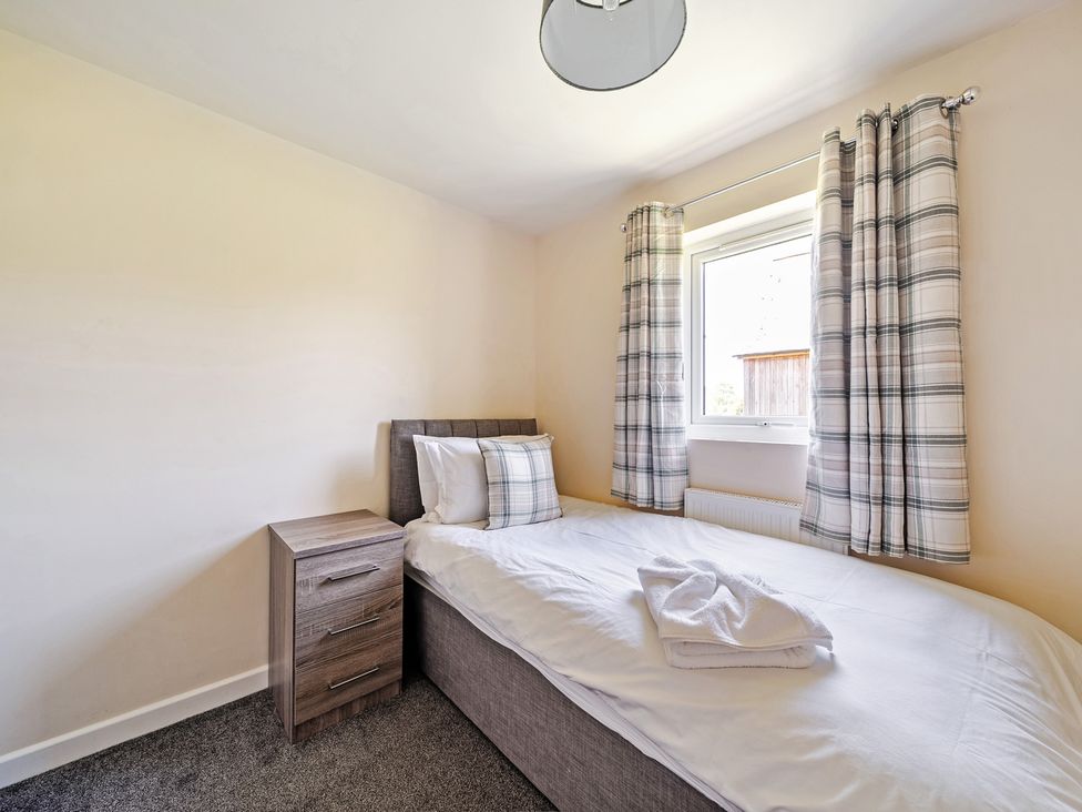 A bedroom with a single bed and nightstand at Sage Lodge Near Brigg