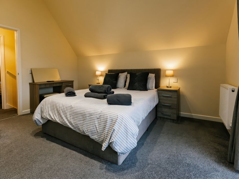 A bedroom with a bed and bedside table at Raven Lodge in Brigg
