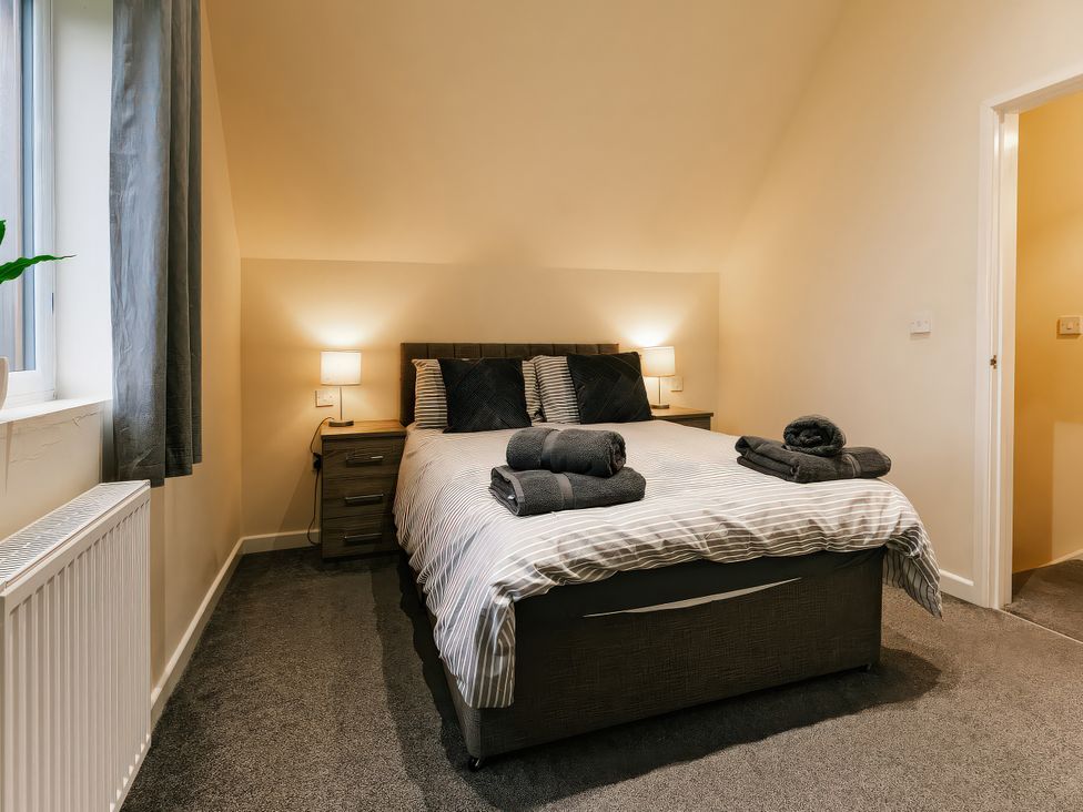 A bedroom with a bed and bedside table at Raven Lodge in Brigg
