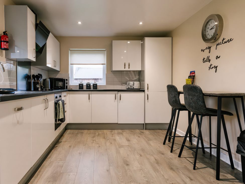 A kitchen with appliances and seating at Raven Lodge in Brigg