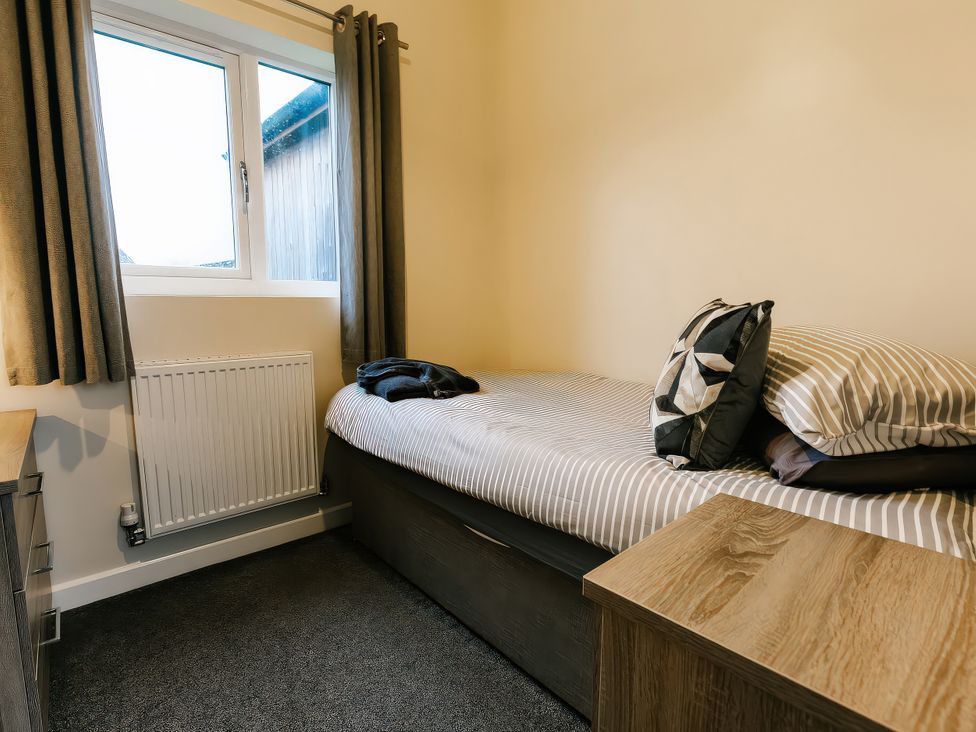 A bedroom with a bed and a radiator at Raven Lodge in Brigg
