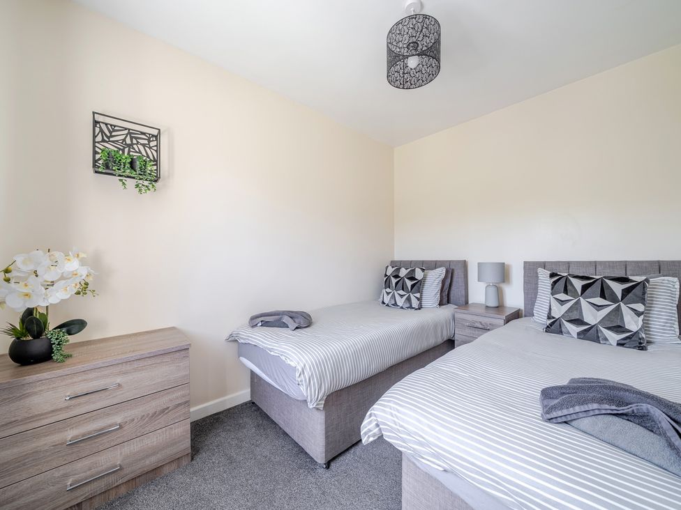 A bedroom with two beds and a dresser at Raven Lodge Near Brigg
