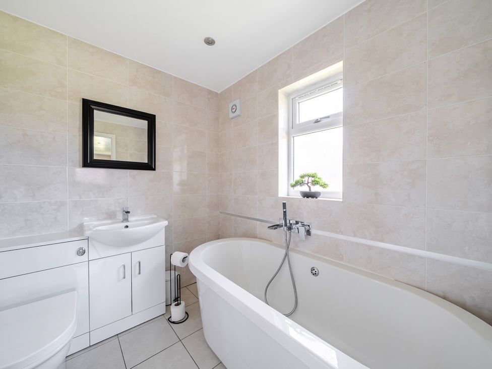 A bathroom with a bathtub, sink, and toilet at Raven Lodge near Brigg