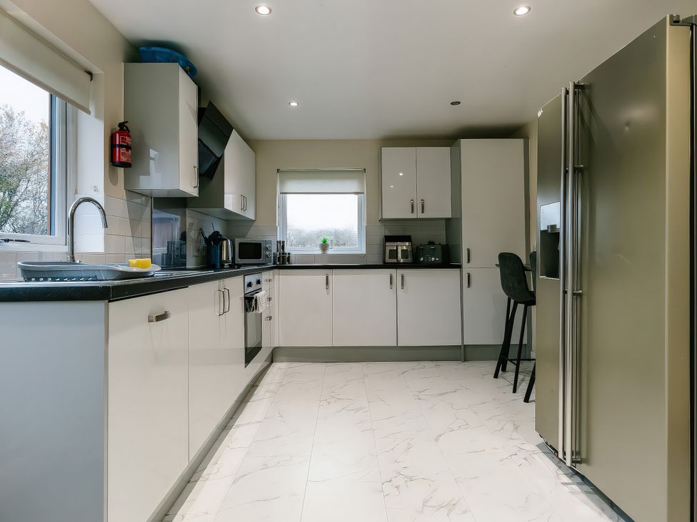 A kitchen with appliances and cabinets at Paddington Lodge in Brigg