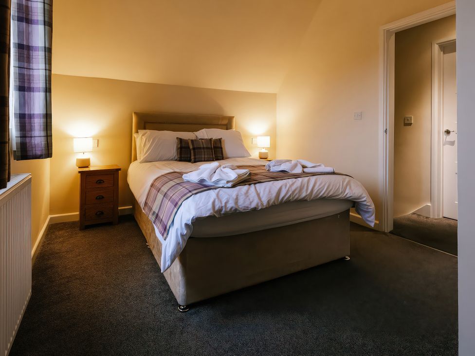 A bedroom with a bed and bedside lamps at Paddington Lodge in Brigg