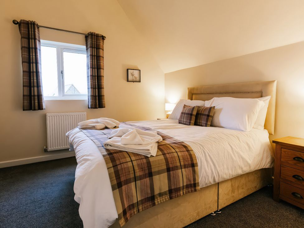 A bedroom with a bed and curtains at Paddington Lodge in Brigg