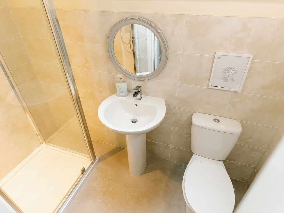 A bathroom with a sink, toilet, and shower at Paddington Lodge in Brigg