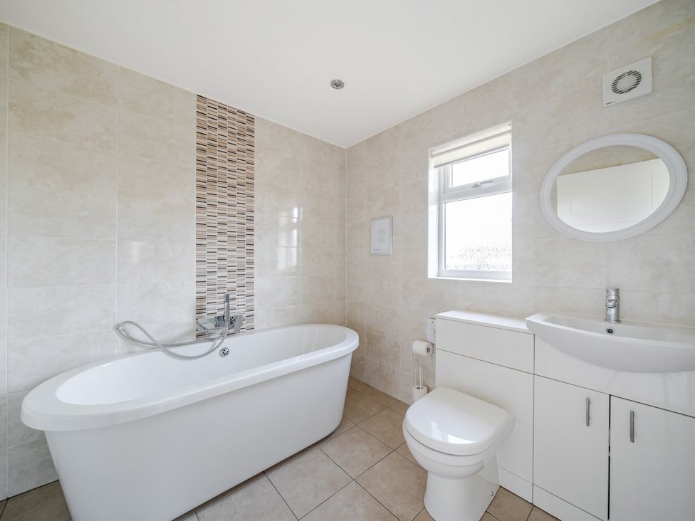 A bathroom with a bath tub and sink at Paddington Lodge Near Brigg