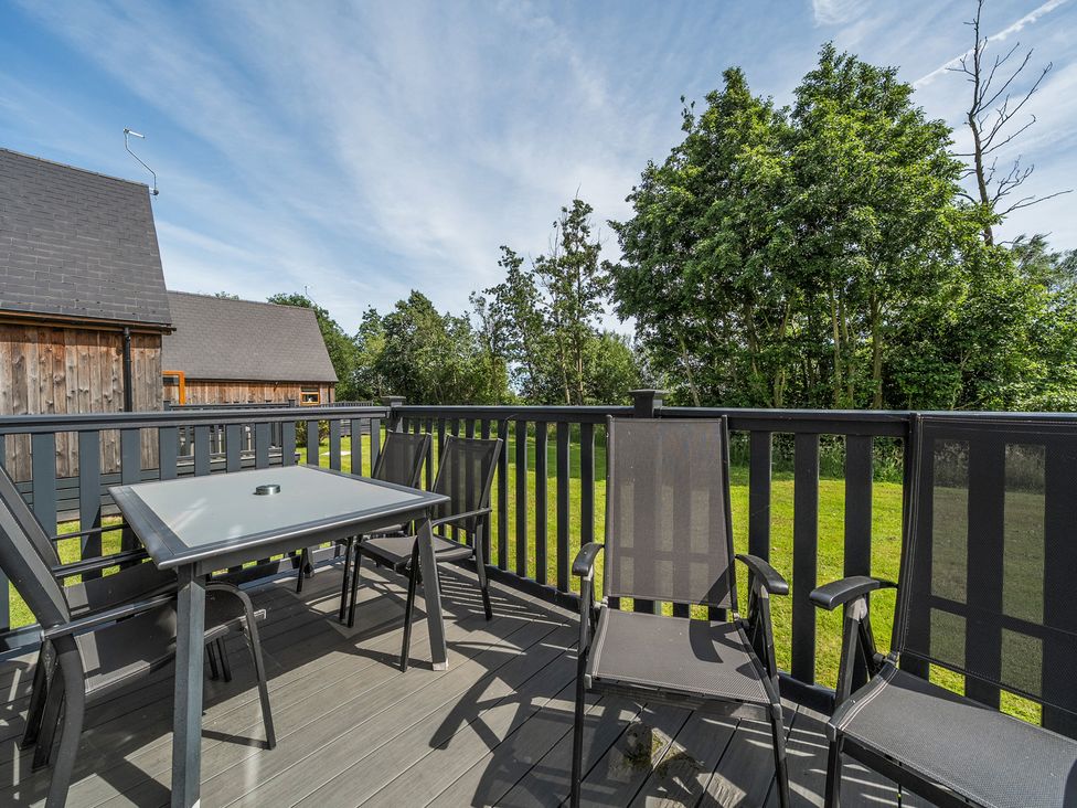 A deck with chairs and a table at Paddington Lodge Near Brigg