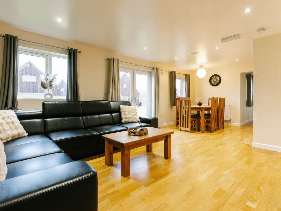 A living room with a sofa and dining area at Charcoal Lodge in Brigg