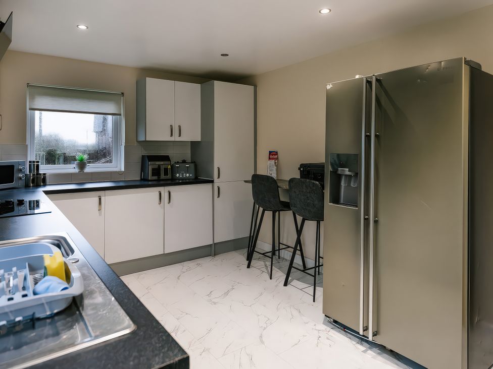 A kitchen with a refrigerator and counter at Charcoal Lodge in Brigg