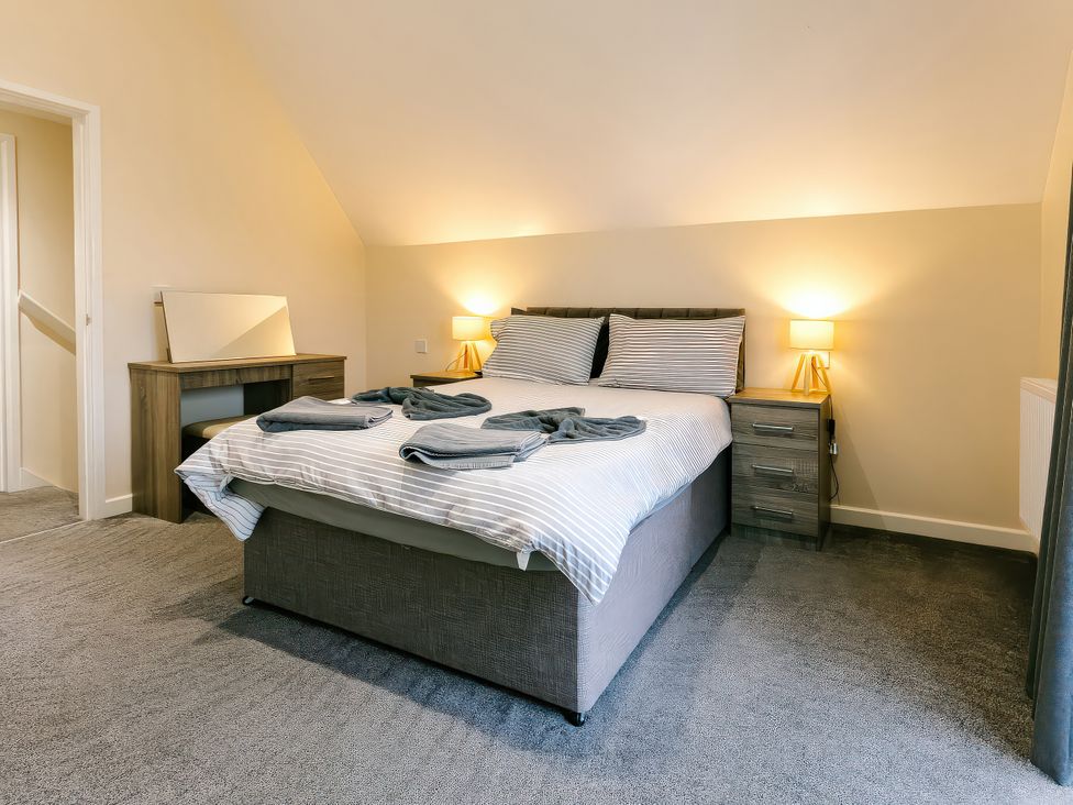A bedroom with a bed and dresser at Charcoal Lodge in Brigg