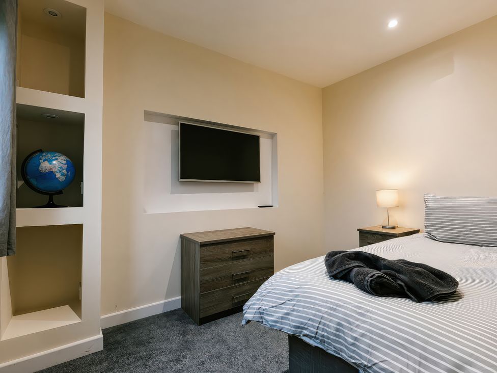 A bedroom featuring a bed, nightstand, and globe at Charcoal Lodge in Brigg