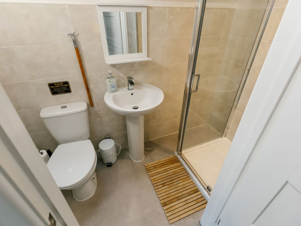 A bathroom with a shower, toilet, and sink at Charcoal Lodge in Brigg