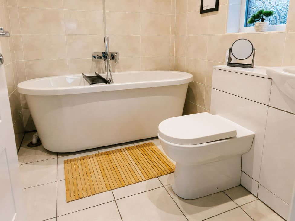 A bathroom with a bathtub and a toilet at Charcoal Lodge in Brigg
