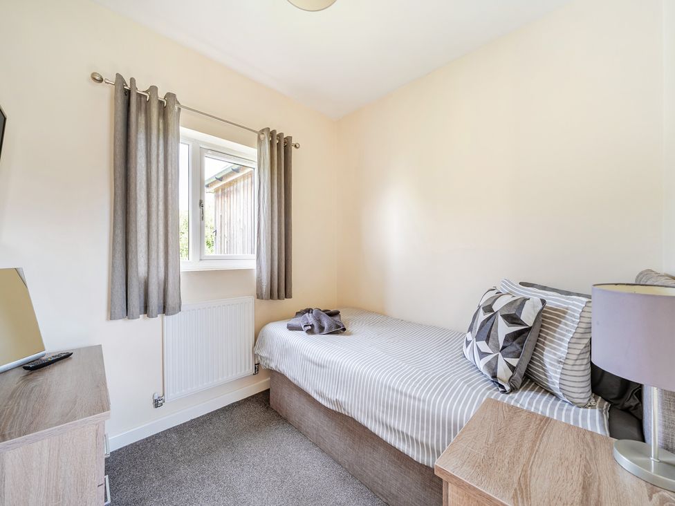 A bedroom with a bed and television at Charcoal Lodge in Brigg