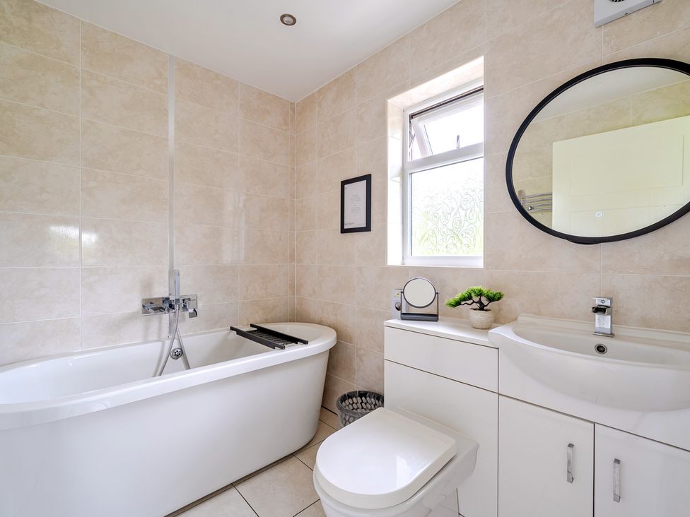 A bathroom with a bathtub, toilet, and sink at Charcoal Lodge Brigg