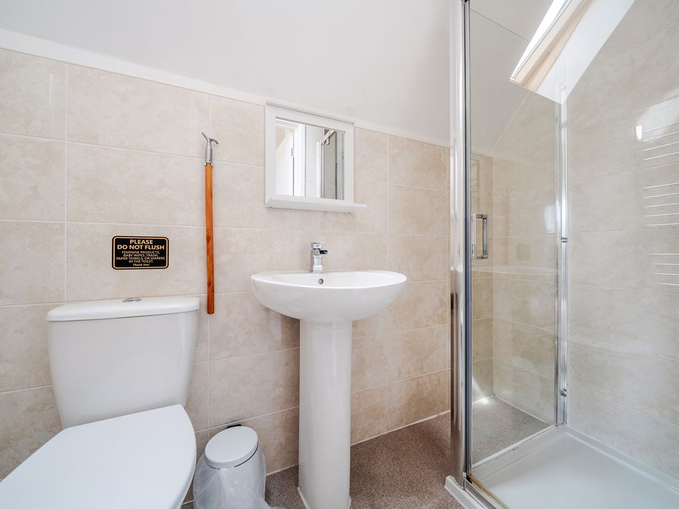 A bathroom with a toilet, sink, and shower at Charcoal Lodge in Brigg