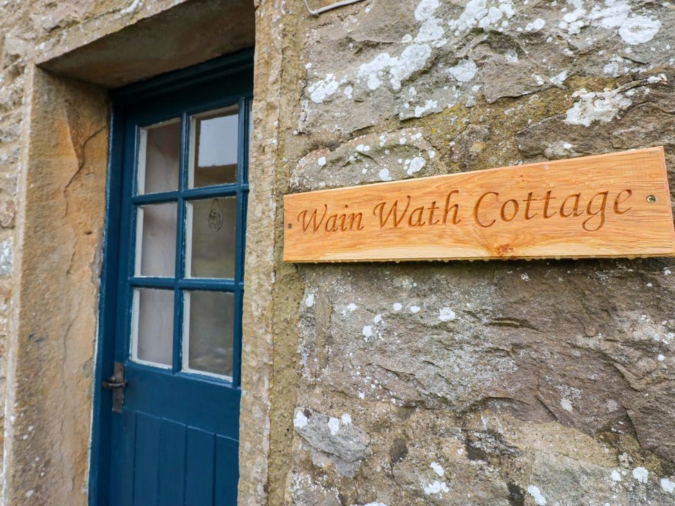 An entryway with a blue door and a sign at Wain Wath Cottage in Richmond