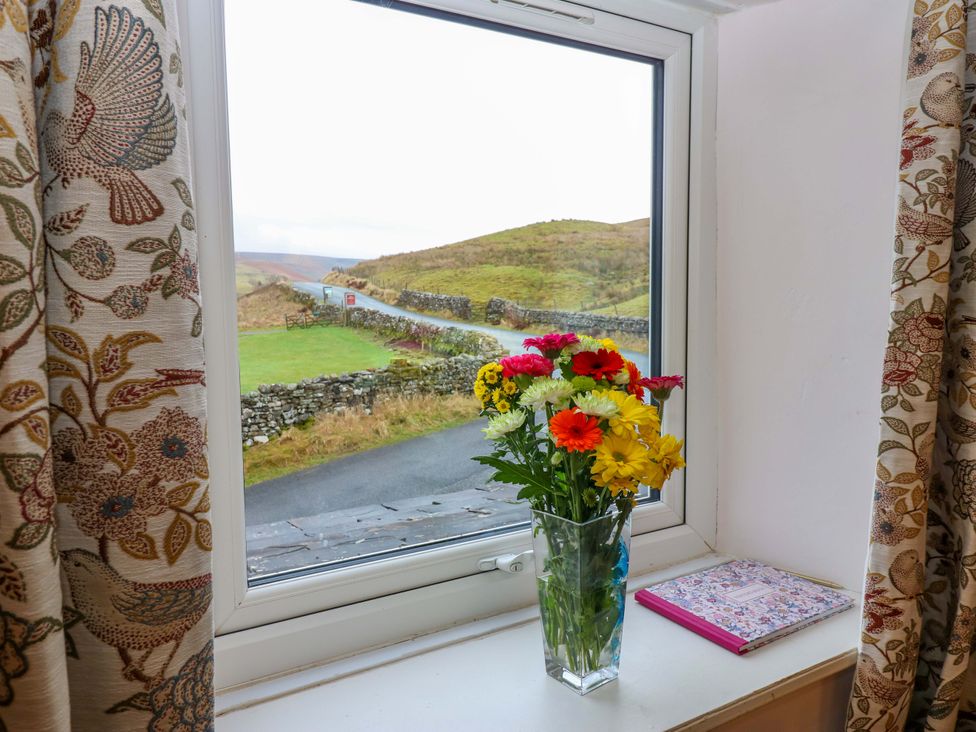 A window with flowers and a notebook at Wain Wath Cottage Richmond