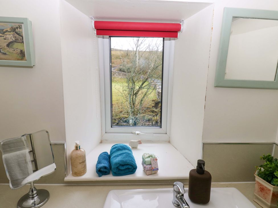 A bathroom with a window and towels at Wain Wath Cottage in Richmond