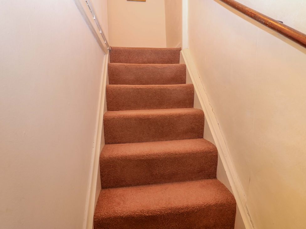 A staircase with brown carpet and handrail at Wain Wath Cottage Richmond