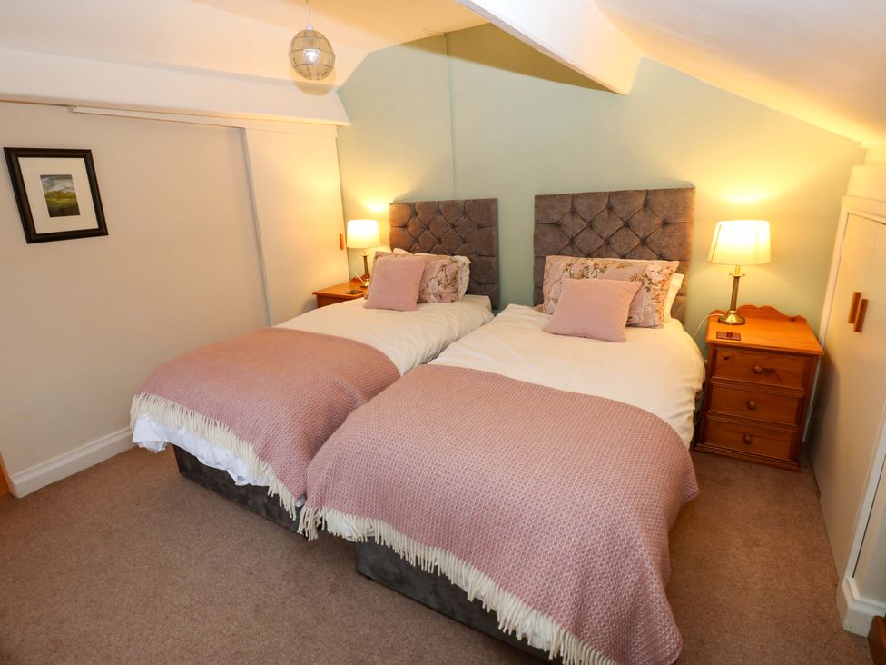 A bedroom with twin beds and a bedside table at Wain Wath Cottage, Richmond