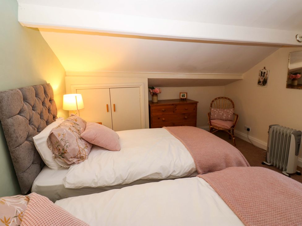 A bedroom with twin beds and decorative furniture at Wain Wath Cottage in Richmond