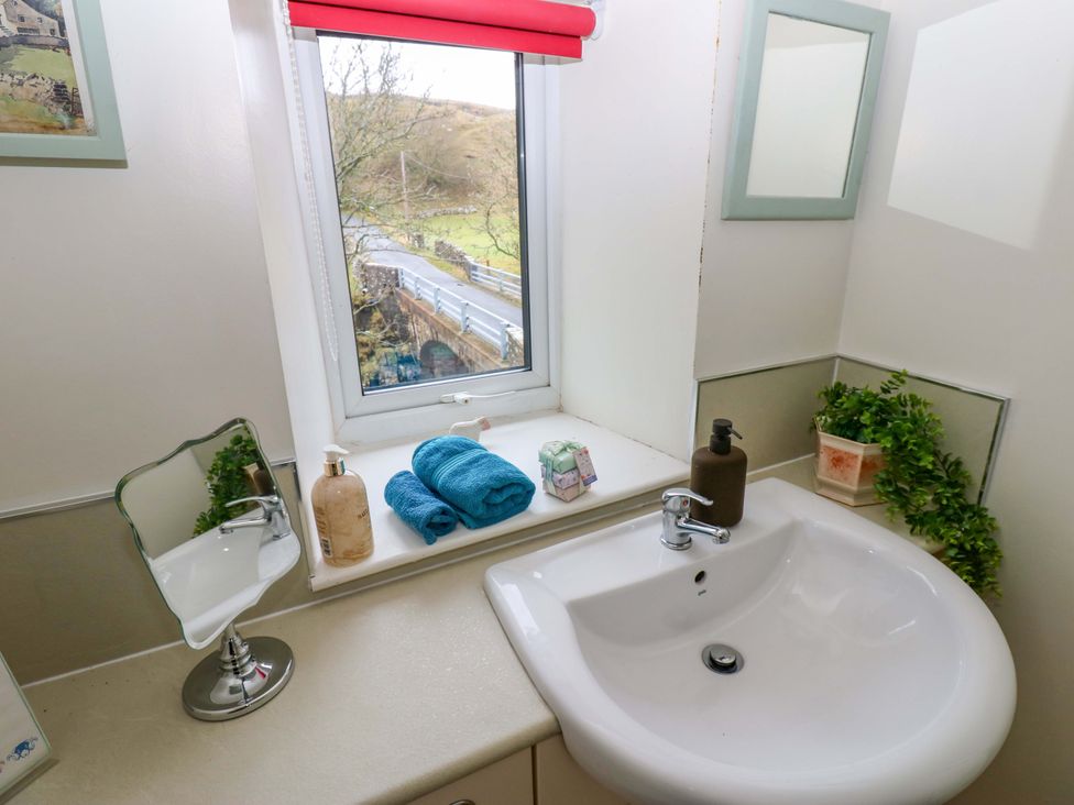 A bathroom with a sink and towels at Wain Wath Cottage in Richmond