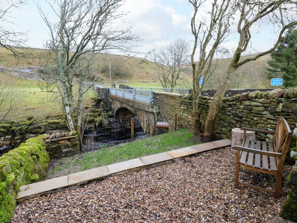 An outdoor area with a bridge and a bench at Wain Wath Cottage Richmond