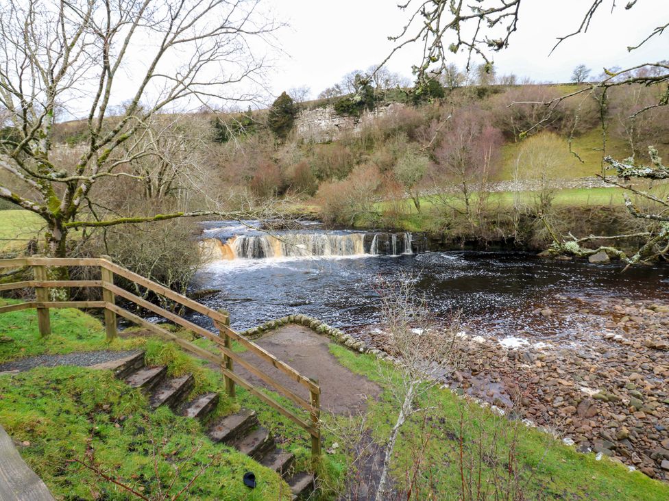 A waterfall and river with steps and trees at Wain Wath Cottage in Richmond