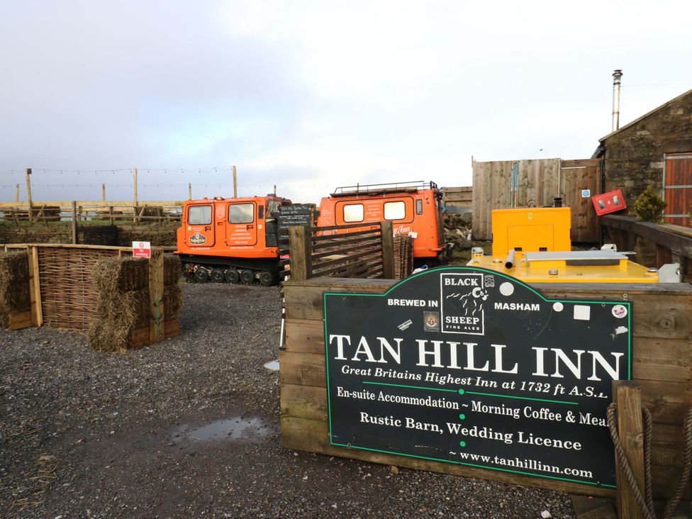 An outdoor area with vehicles and signage at Tan Hill Inn in Richmond