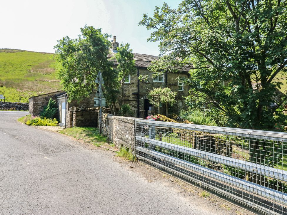 A house with trees and a gate at Wain Wath Cottage in Keld near Muker