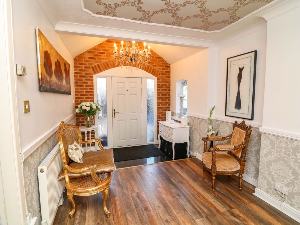 A hallway with a chandelier and chairs at 12 Wyndham Road in Loughborough