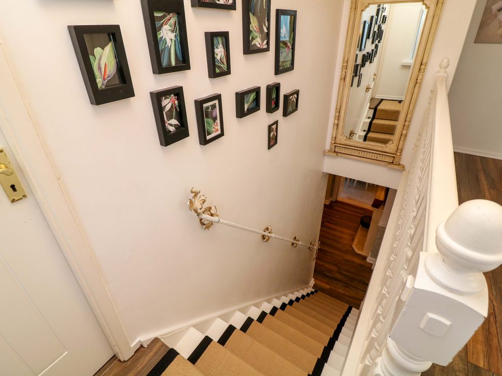 A staircase with frames on the wall at 12 Wyndham Road in Loughborough