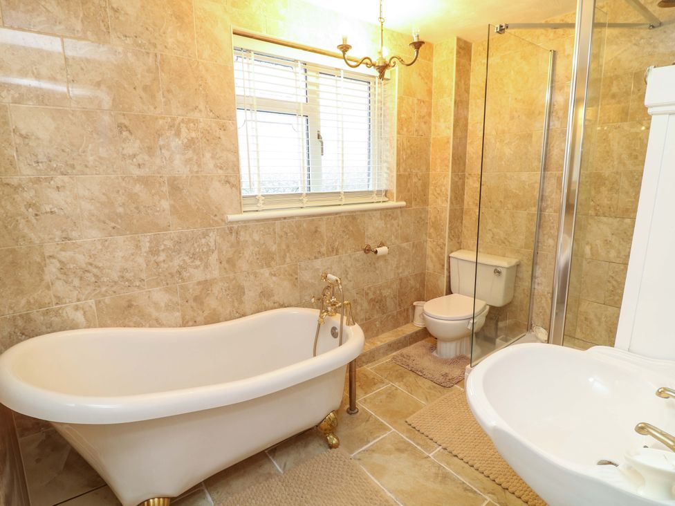A bathroom with a bathtub, shower, toilet and sink at 12 Wyndham Road in Loughborough