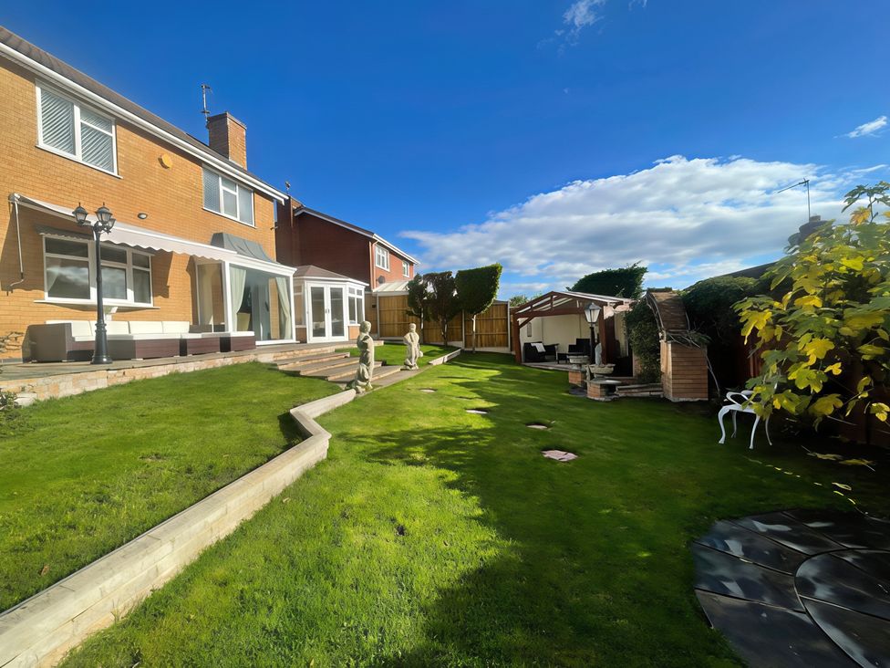 A garden with a lawn and patio at Ivy's End in Loughborough