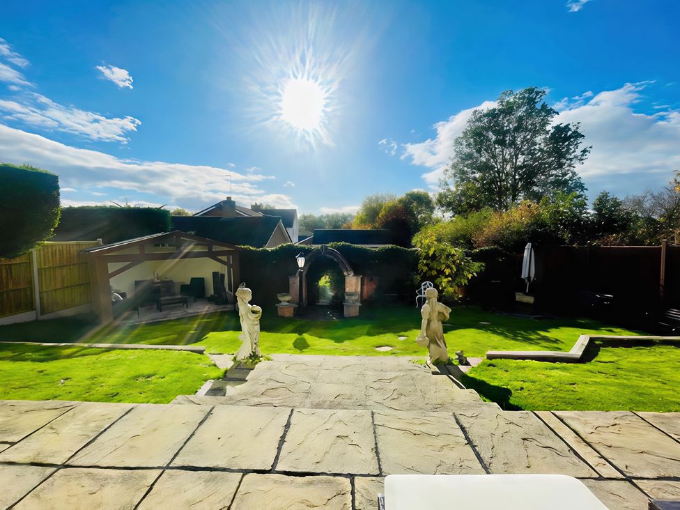 A garden with statues and a pathway at Ivy's End in Loughborough