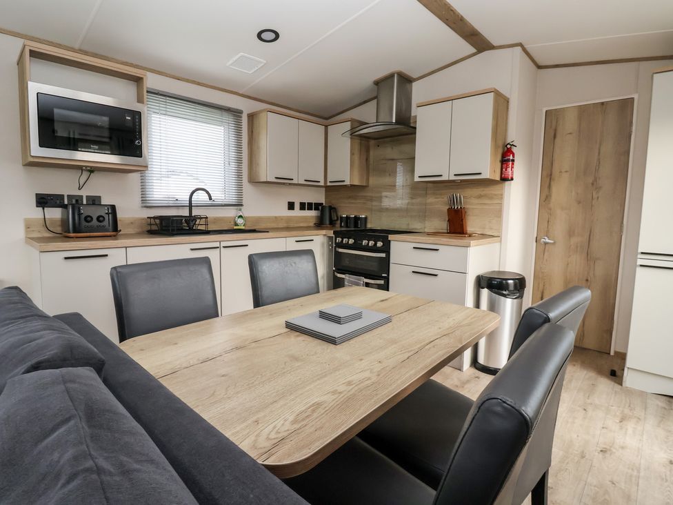 A kitchen with table and chairs at The Driftwood in High Skirlington near Skipsea