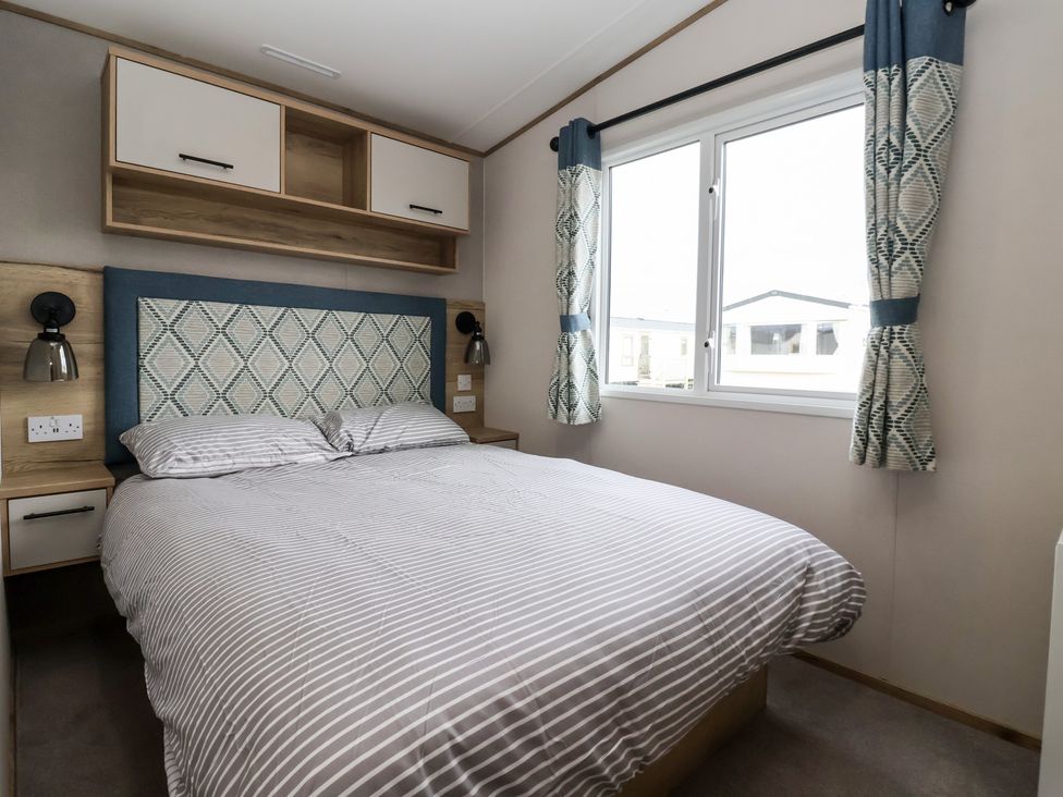 A bedroom with a bed and shelf at The Driftwood near High Skirlington