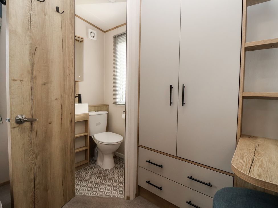 A bathroom with a toilet and sink at The Driftwood in High Skirlington near Skipsea