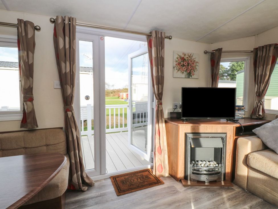 A living room with a television and fireplace at 46 Foxburrow Hang in Great Yarmouth