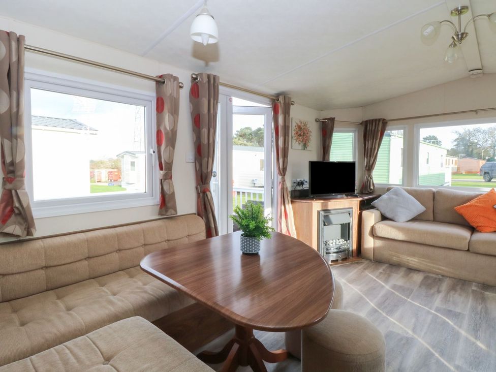 A living room with a table and couch at 46 Foxburrow Hang in Great Yarmouth