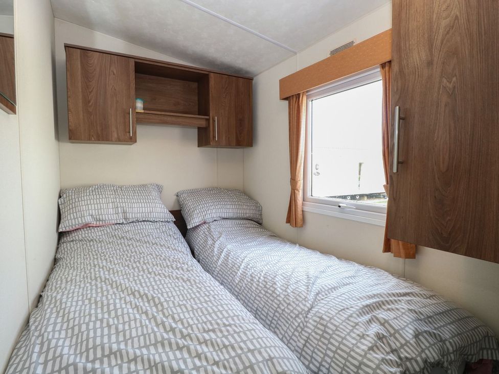 A bedroom with two beds and a shelf at 46 Foxburrow Hang in Great Yarmouth