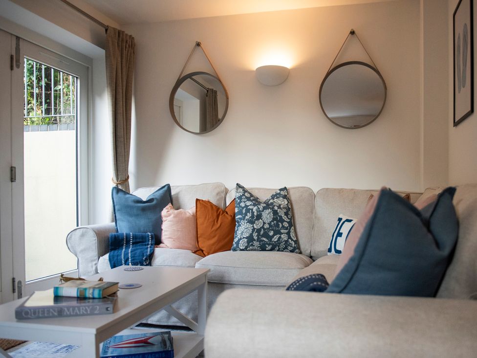 A living room with a sofa and pillows at The Old Boat House in Lyme Regis